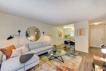 Living room with hardwood inspired flooring, white couch and coffee table.